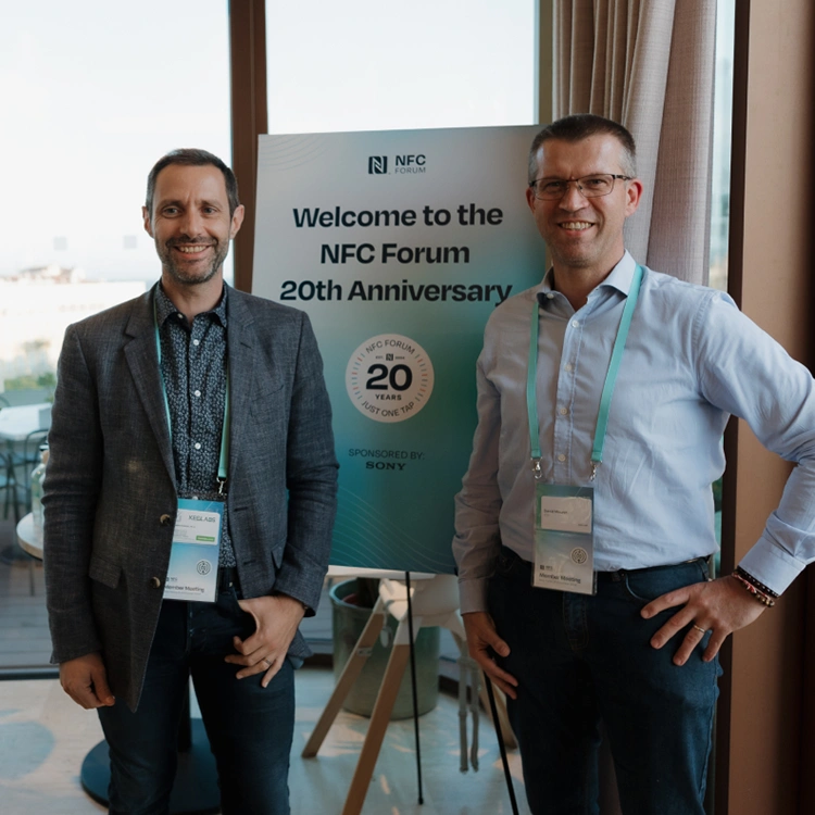 Two attendees posing for a photo at the 20th anniversary of the NFC Forum