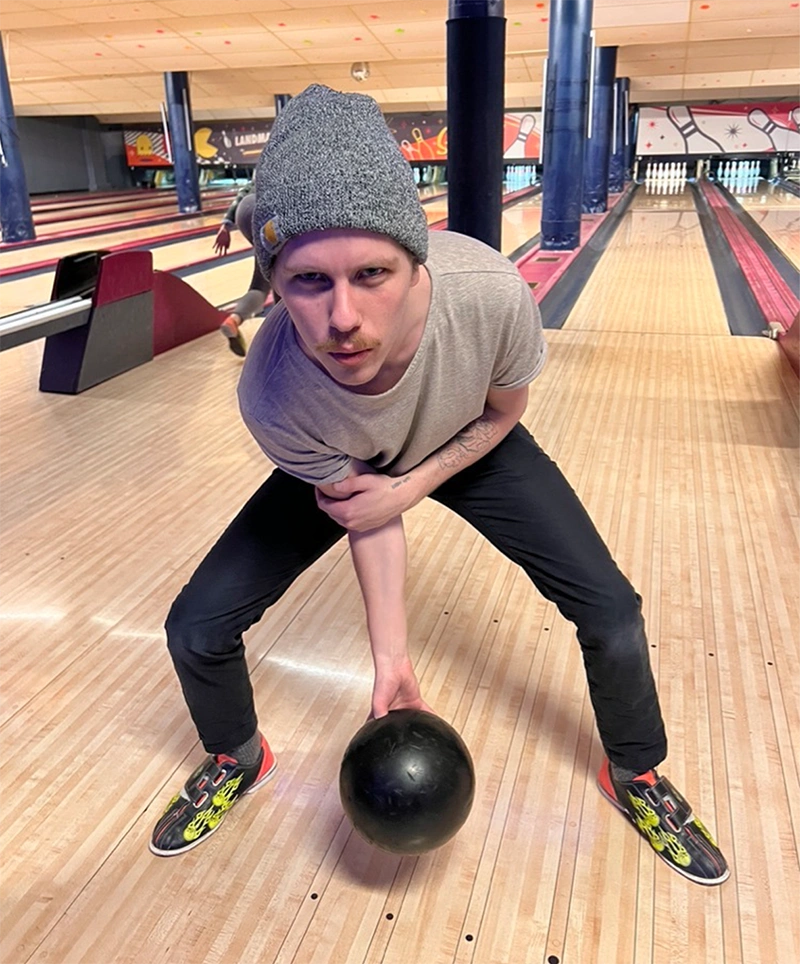 Nate holds a bowling ball, ready to smash some pins at the alley.