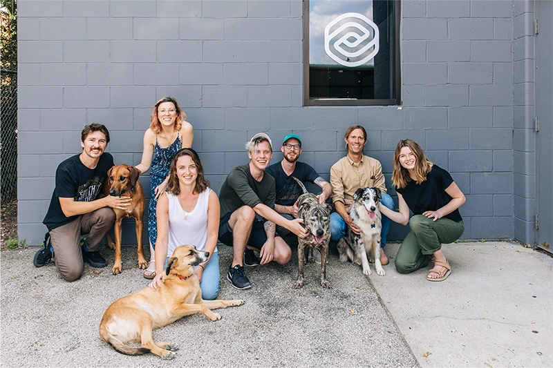 Milwaukee Crew + dogs, posing for a photo behind the office building